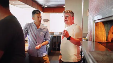 Wilson K Lee talking in the kitchen at Nook, beside the pizza oven